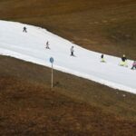 Skiers gliding down an artificial snow slope